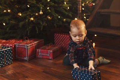 Portrait of cute baby girl standing by christmas tree