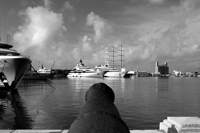 Sailboats moored in sea against sky