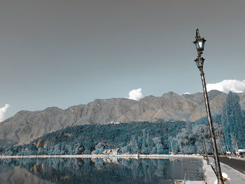 Scenic view of lake by snowcapped mountains against sky