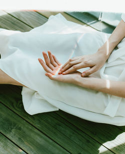 Midsection of woman sitting on wooden floor