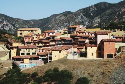 Houses in town by mountains against sky