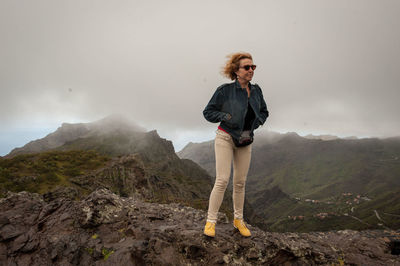 Full length of mature woman standing on mountain