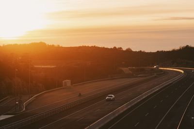 Aerial view of highway against sky during sunset