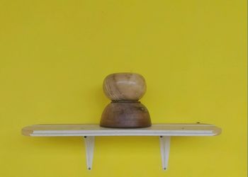 Close-up of empty table against yellow wall