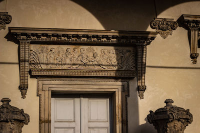 Low angle view of old stone carving against building