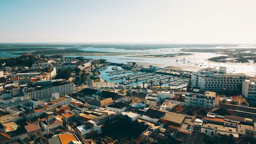 High angle view of cityscape by sea against clear sky