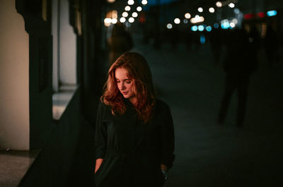 Young woman with eyes closed at night