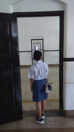 Rear view of girl standing in corridor