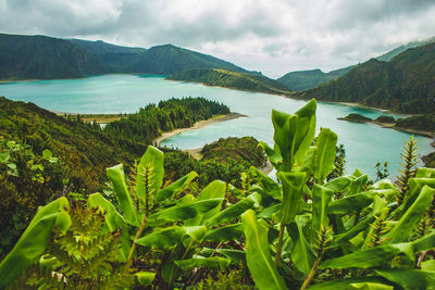 Scenic view of sea by mountains against sky