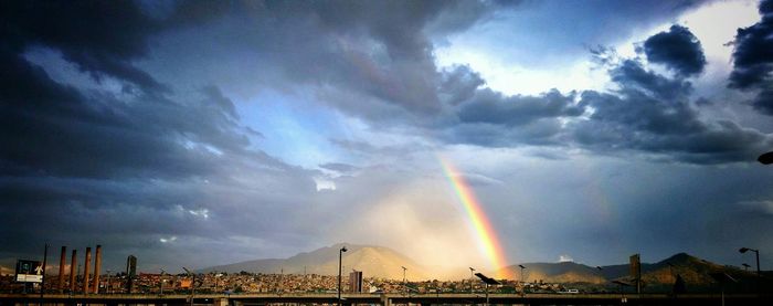 Panoramic view of rainbow over city against sky