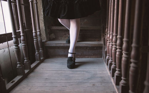 Low section of woman standing on a wooden staircase