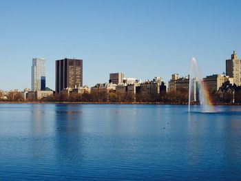 City at waterfront against clear sky