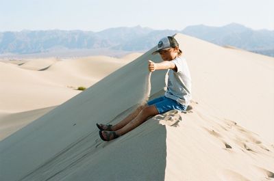 Rear view of boy on desert