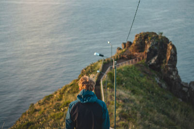 Student wearing a jacket enjoys the view from cristo rei, camara de lomos, madeira, portugal