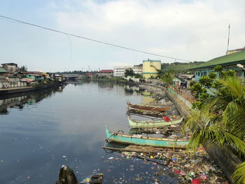 Boats moored on shore against sky