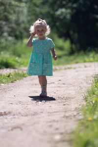 Full length of girl standing against plants