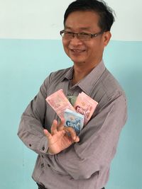 Portrait of a smiling young man holding camera