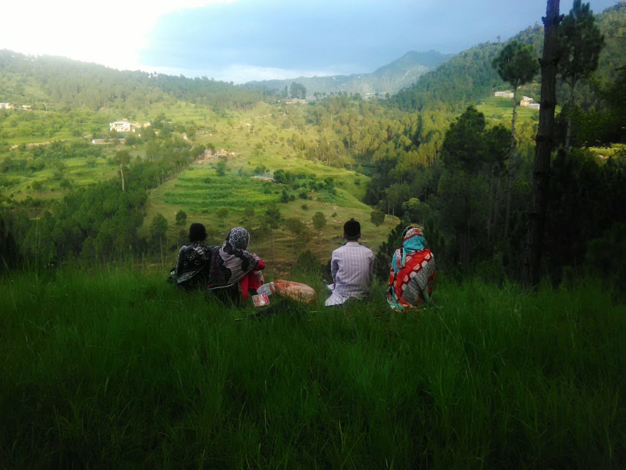 PEOPLE ON FIELD AGAINST MOUNTAINS