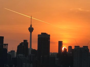 Silhouette of buildings in city during sunset