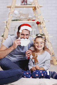 Happy father and daughter with props at home during christmas