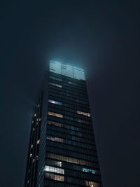 Low angle view of skyscrapers against sky at night