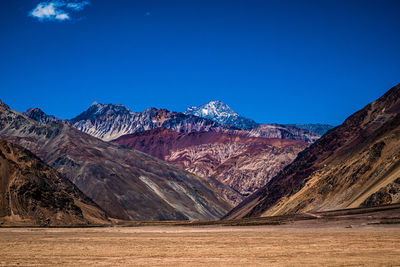 Scenic view of snowcapped mountains against clear blue sky