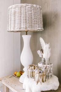 Containers with lighting equipment and fruits on table against wall at home