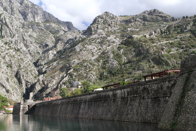 Scenic view of river by mountains against sky