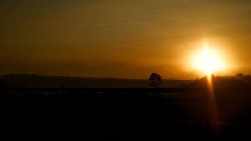 Scenic view of silhouette landscape against orange sky