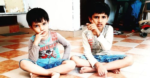 Portrait of cute boy sitting on floor