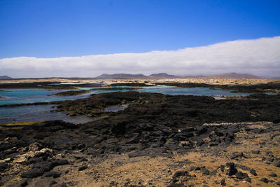 Scenic view of beach against blue sky