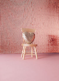 Glitter heart on chair on shiny background. anniversary and valentine's day copy space