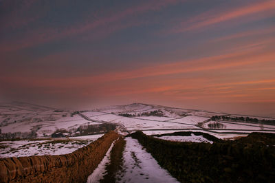 Scenic view of snow covered landscape at sunset
