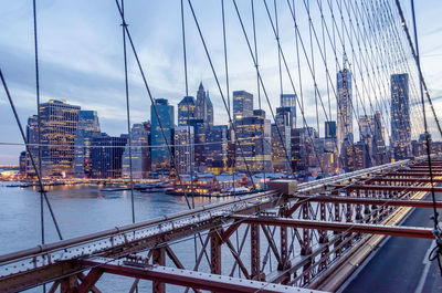 View of suspension bridge and buildings against sky