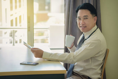 Portrait of smiling man using smart phone