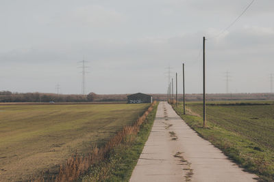 Road amidst field against sky