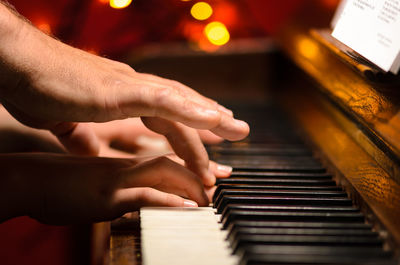 Cropped hands of person playing piano