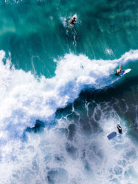 High angle view of people surfing in sea