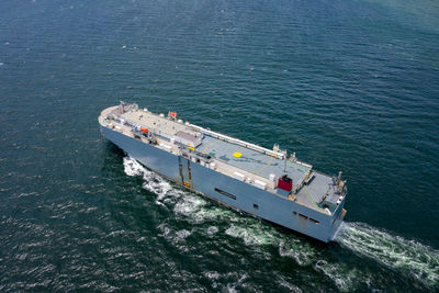 Aerial view of large roro vehicle carrier vessel sailing on the green sea