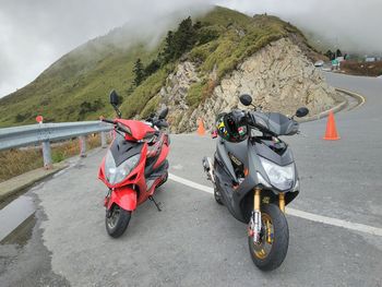 Motor scooter on road against mountain range