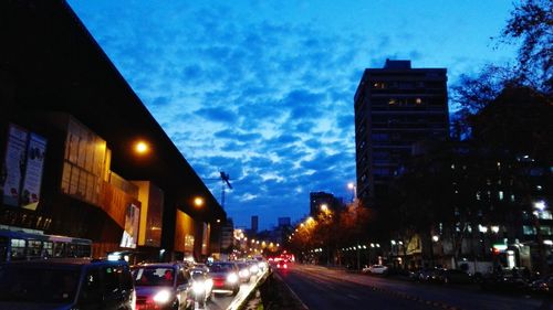 Cars on road along buildings at night