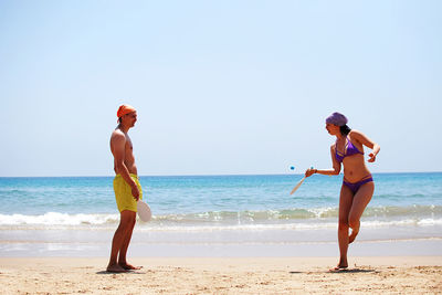 Rear view of couple playing at beach