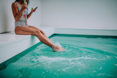 Woman jumping in swimming pool