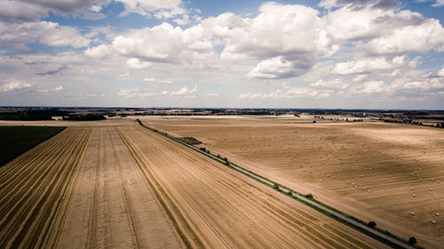 View of wooden pier on beach against cloudy sky