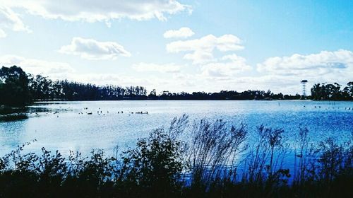 Scenic view of lake against cloudy sky