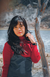 Young woman looking away while standing at beach