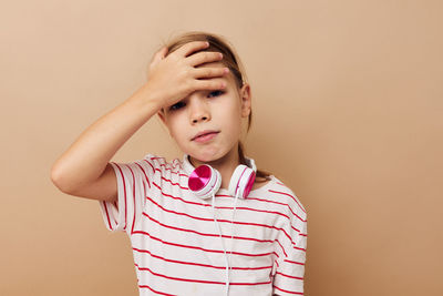 Portrait of depressed girl against beige background