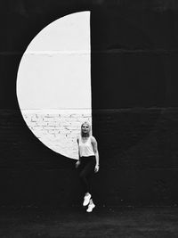 Portrait of woman levitating against wall