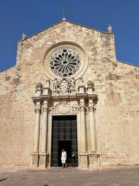 Rear view of woman leaning against building