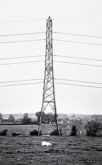 Low angle view of electricity pylon against clear sky